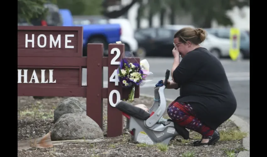 Una mujer reza cerca del área donde un policía perdió la vida en Pomona. FOTO/AP