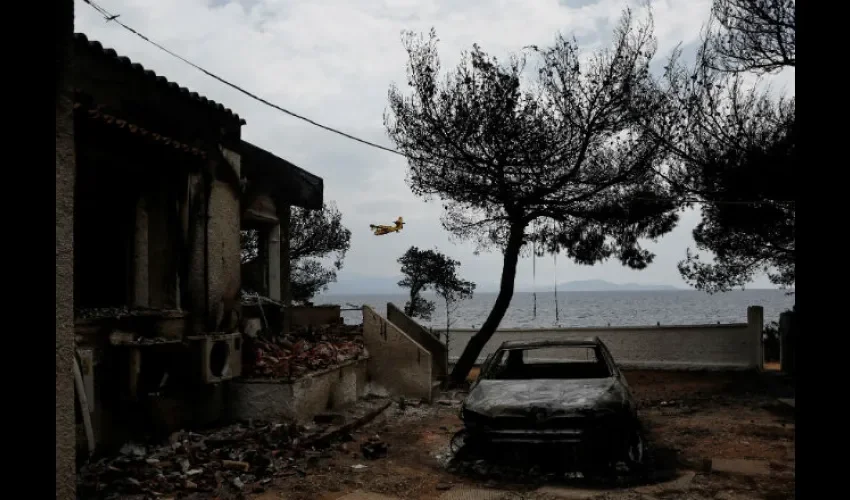 Un hidroavión sobrevuela una zona afectada por el incendio. Foto: EFE